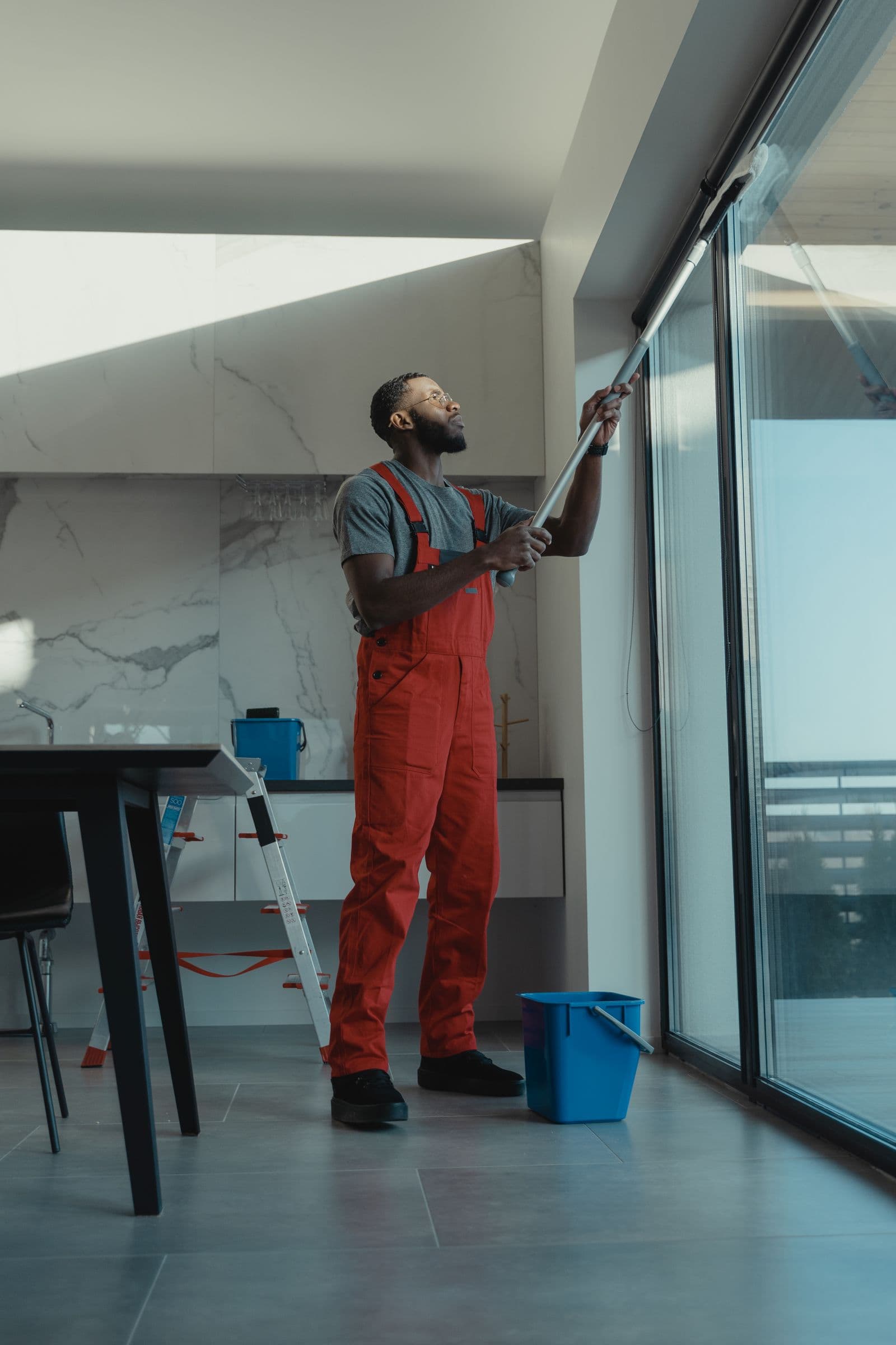 Glasreiniger zieht ein Fenster mit dem Abzieher streifenfrei ab